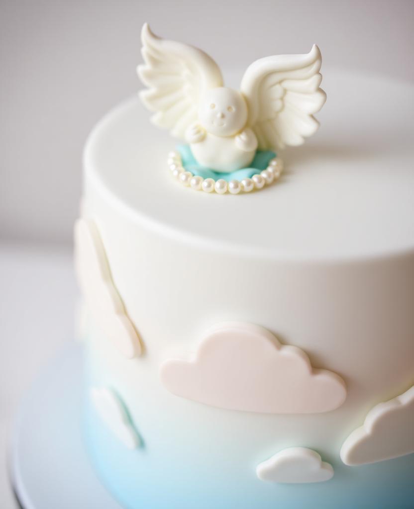 Pastel de bautizo en azul cielo con nubes de fondant y angelito con alas